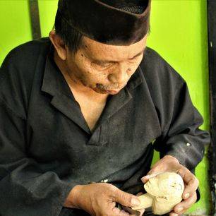 Een local werkt aan een Wayong-pop in Bogor op Java