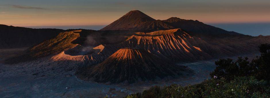 Langzaam wordt de Bromo-vulkaan verlicht tijdens de zonsopkomst, Java