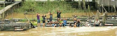 Zwaaiende kinderen aan de Mahakanrivier in Kalimantan
