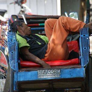 Locale bewonder ligt te slapen in zijn fietstaxi