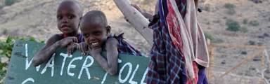 Tanzaniaanse kinderen verkopen water langs de weg
