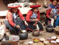 Traditioneel geklede vrouwen kleuren het geweefde wol in Maras, Peru