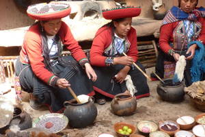 Traditioneel geklede vrouwen kleuren het geweefde wol in Maras, Peru