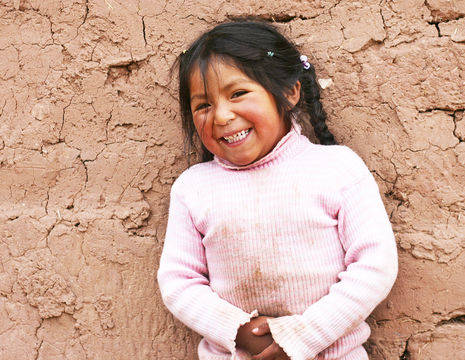 Vrolijk meisje in het authentieke dorp Guamote