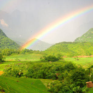De regenboog over de groene bosrijke omgeving van Pu Luong